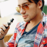 man sitting in a cafe with vape