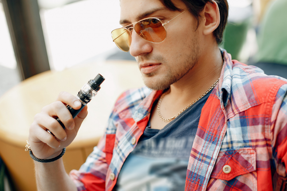 man sitting in a cafe with vape